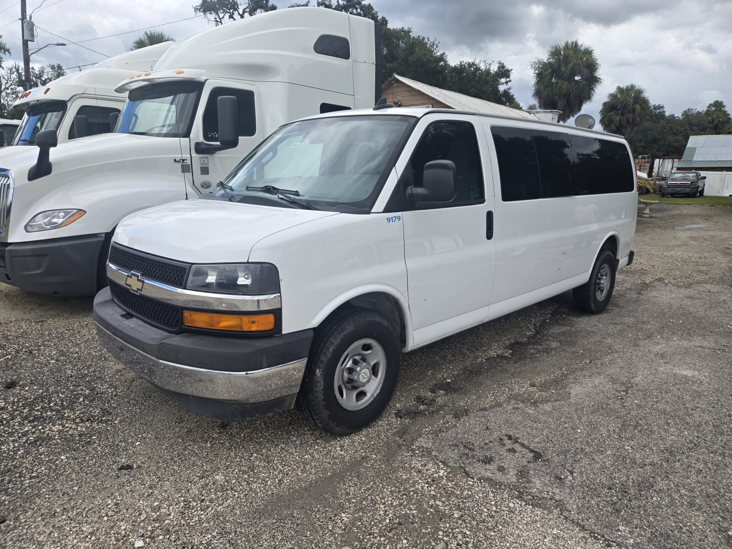 2017 Chevrolet Express 3500 white passenger van in a used vehicle lot, side view with front grille and chrome bumper visible.