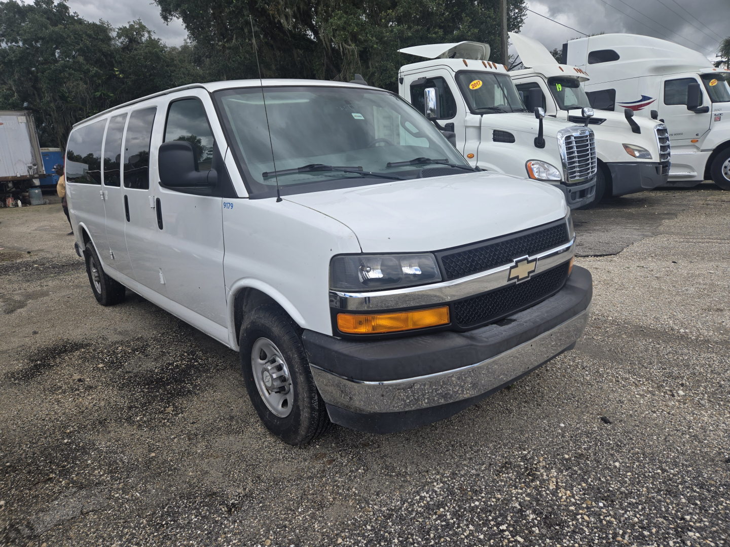 Chevrolet Express 3500 passenger van side/front view showing white body, black grille, and Chevrolet emblem.