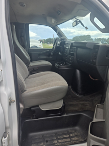 Interior of a 2017 Chevrolet Express 3500 cargo/passenger van showing front seats, dashboard, and steering wheel from the driver’s side.