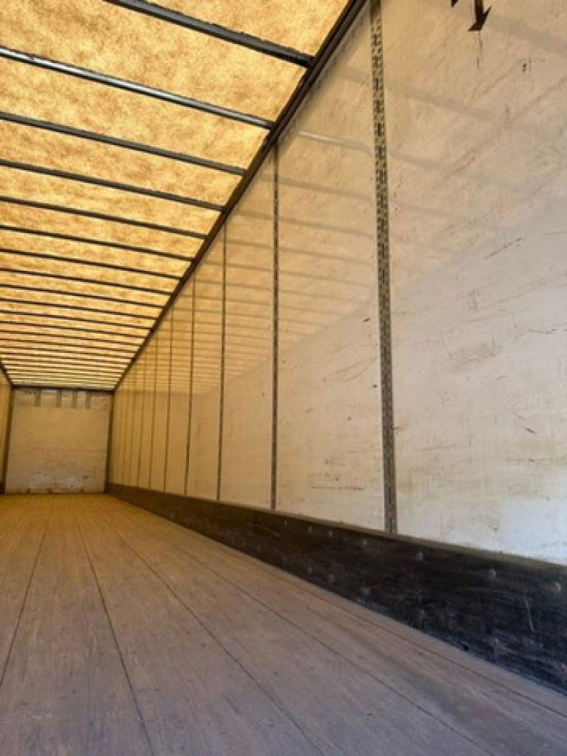 Trailer interior showing wooden floor and aluminum side walls of a 2016 Wabash van trailer, empty cargo space.