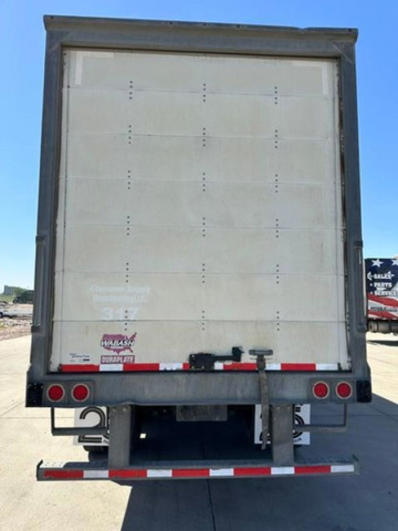 Rear view of a 2016 Wabash van trailer showing a vertical hinged rear door, bumper light bar, and reflective safety tape along the lower edge.