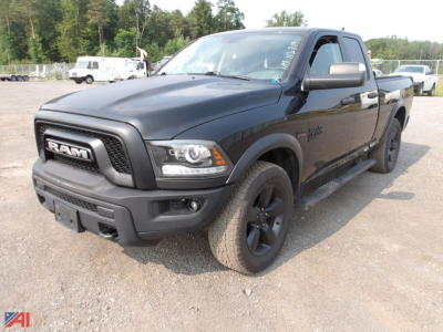 Ram 1500 pickup truck in black exterior, crew cab, front three-quarter view showing bold grille, headlights, and black wheels.