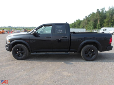 Black 2020 Ram 1500 Classic Crew Cab pickup truck side view with chrome grille, black wheels, and bed cap; small white writing on rear door window.