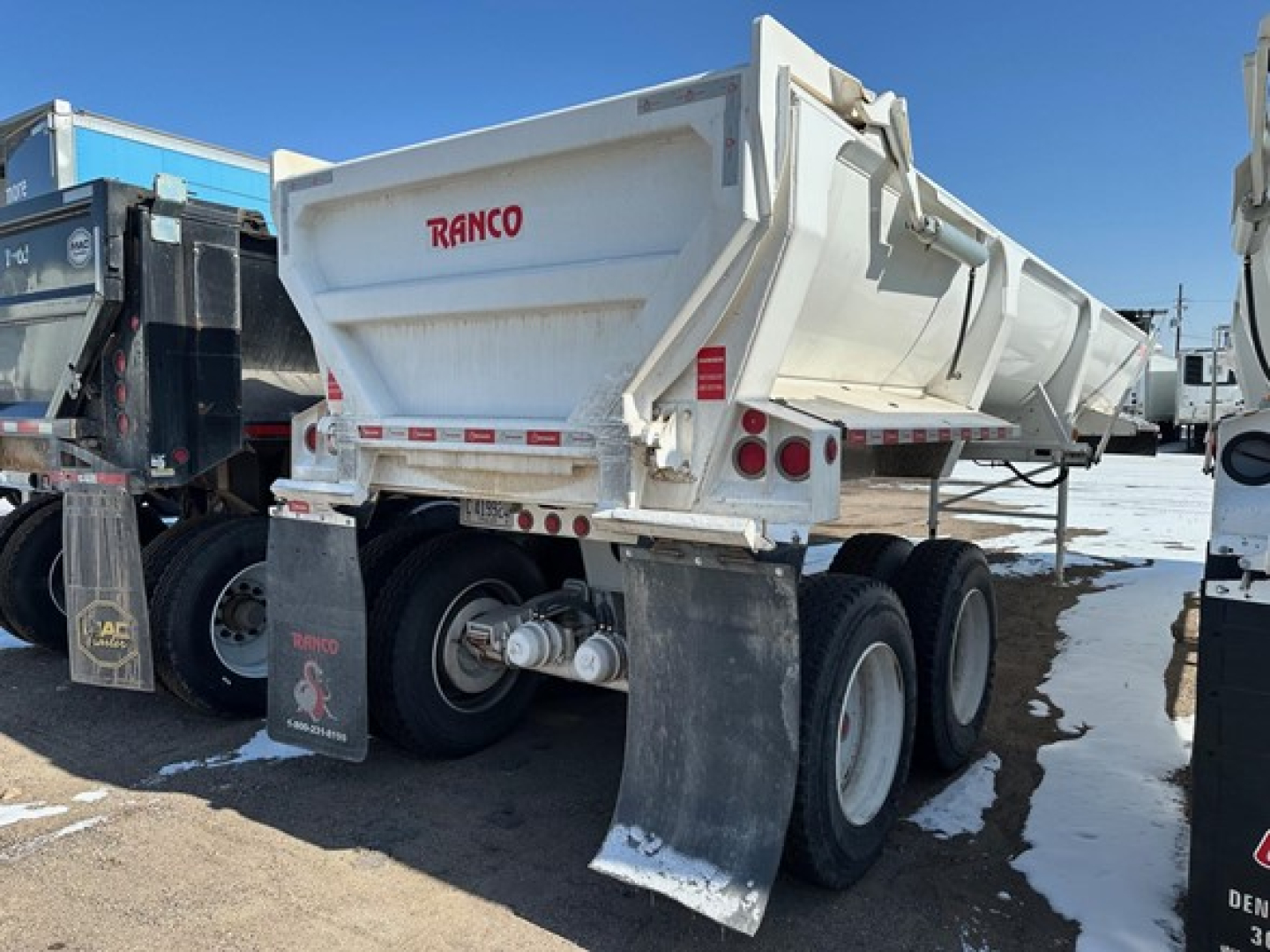 Ranco ED26-34 dump trailer showing rear and left side with 'RANCO' logo and dual wheels with mud flaps.