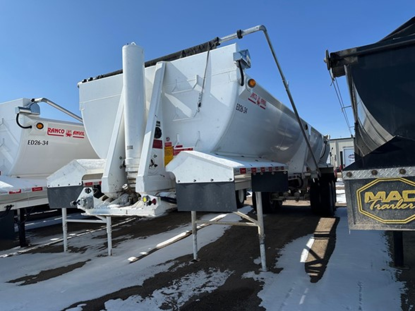 Ranco Ed26-34 dump trailer showing hydraulic system and rear discharge chute with metal frame and hitch.