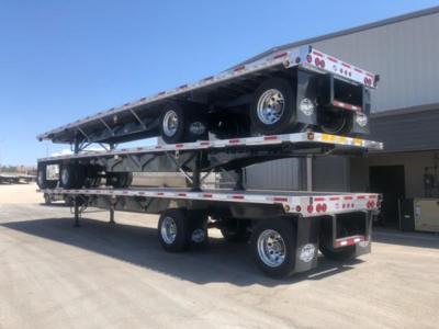 Flatbed trailer stacked on two levels with wheels visible, Utility brand, 2027 model, 4000Ae, license plate area and rear lighting visible.