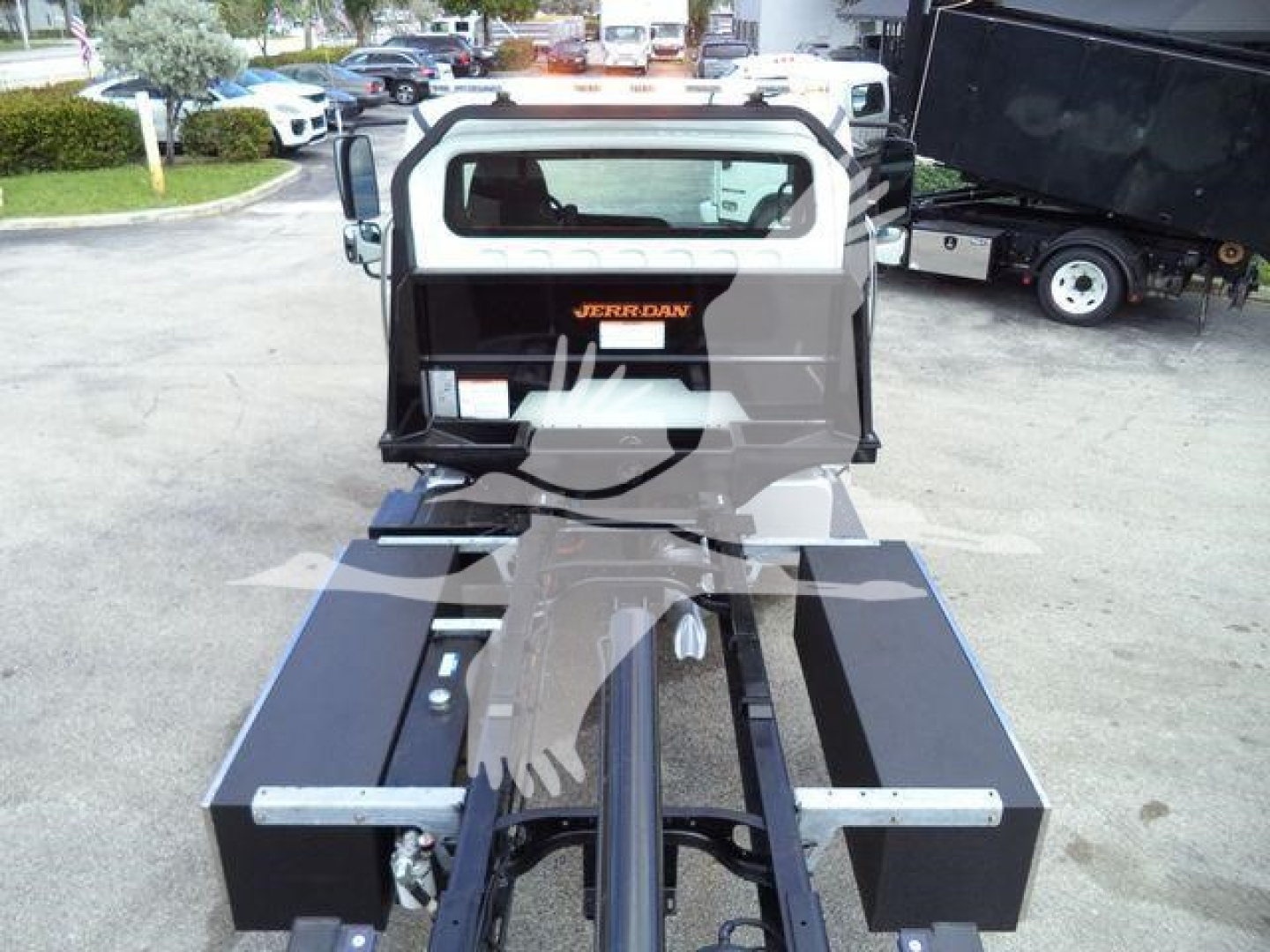 Front view of a 2019 Freightliner M2 106 rollback chassis showing rear cab, hydraulic lines, and toolboxs on sides.