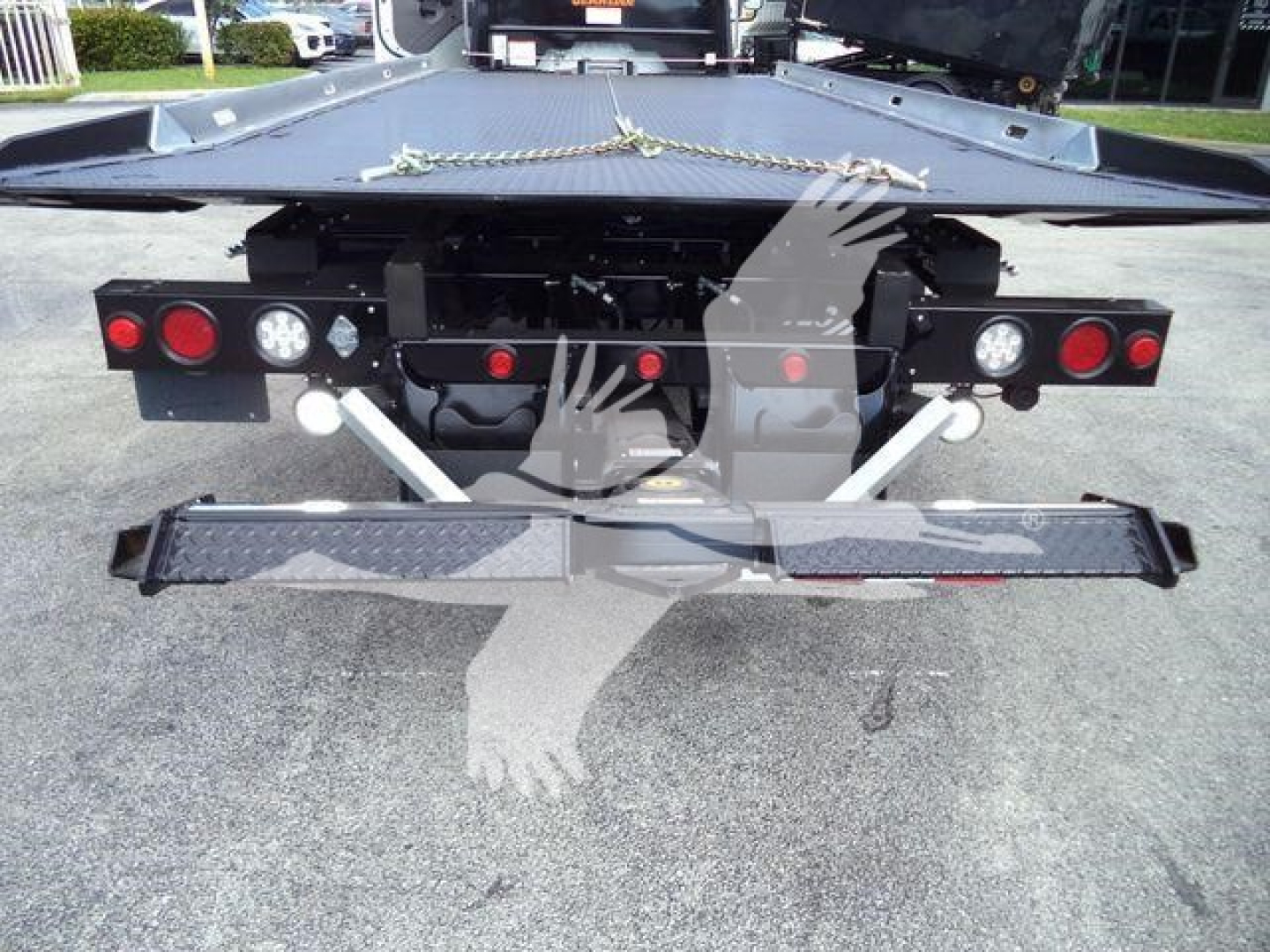 Freightliner M2 106 rollback rear view showing bumper, tail lights, and hitch assembly.