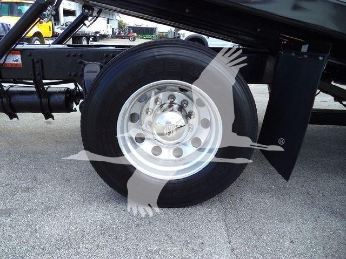 Freightliner M2 106 rear wheel well showing tire and aluminum wheel with hub cap and fender undercarriage.