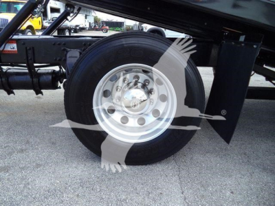 Freightliner M2 106 rear wheel well showing tire and aluminum wheel with hub cap and fender undercarriage.