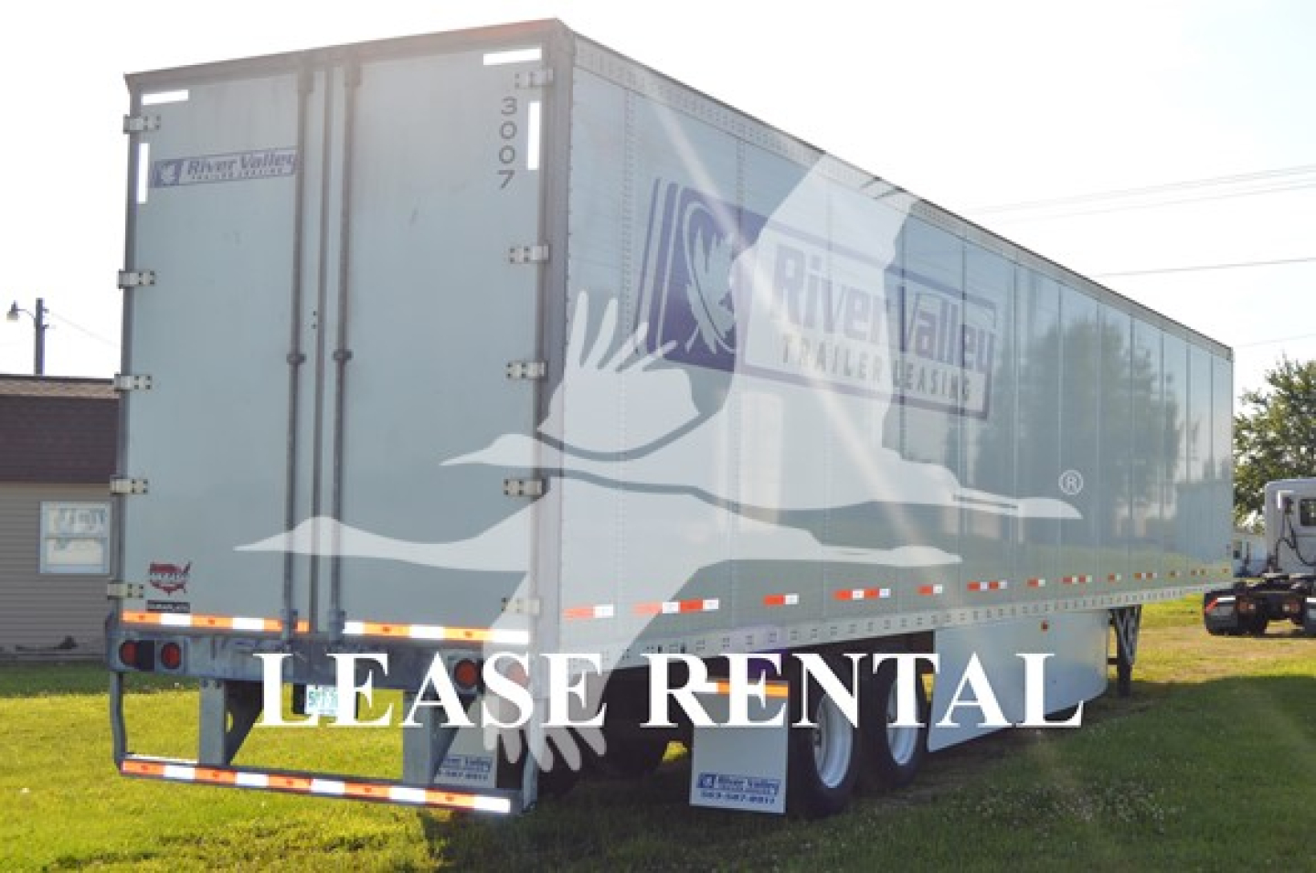 Trailer rear showing LEASE RENTAL text and Wabash Duraplate trailer with River Valley Truck &… branding, side decals and triple-axle wheels.