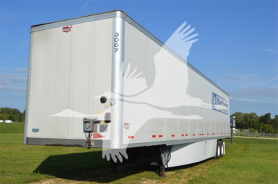 Trailer side and rear view showing Wabash Duraplate trailer with white exterior, rear bumper, wheels, and branding visible.