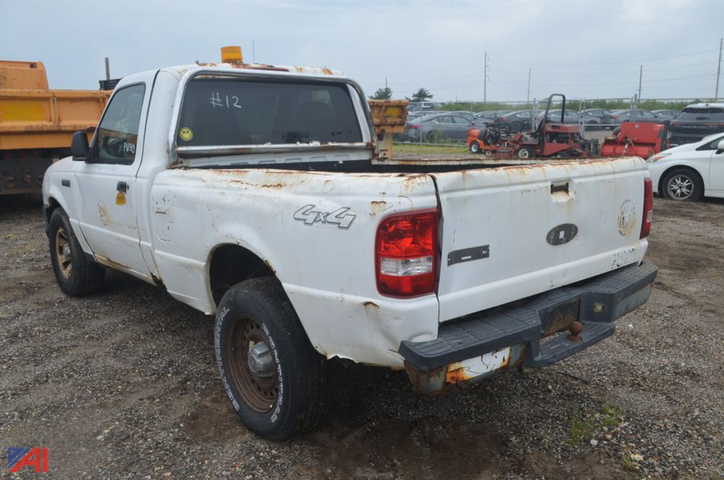 Ford Ranger pickup truck 4x4 rear view showing bed damage and rust, white exterior, tailgate and bumper.