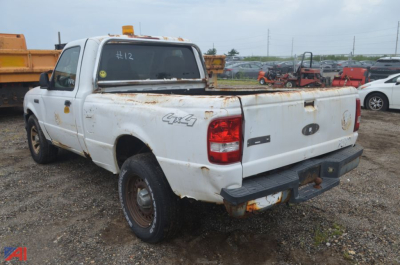 Ford Ranger pickup truck 4x4 rear view showing bed damage and rust, white exterior, tailgate and bumper.