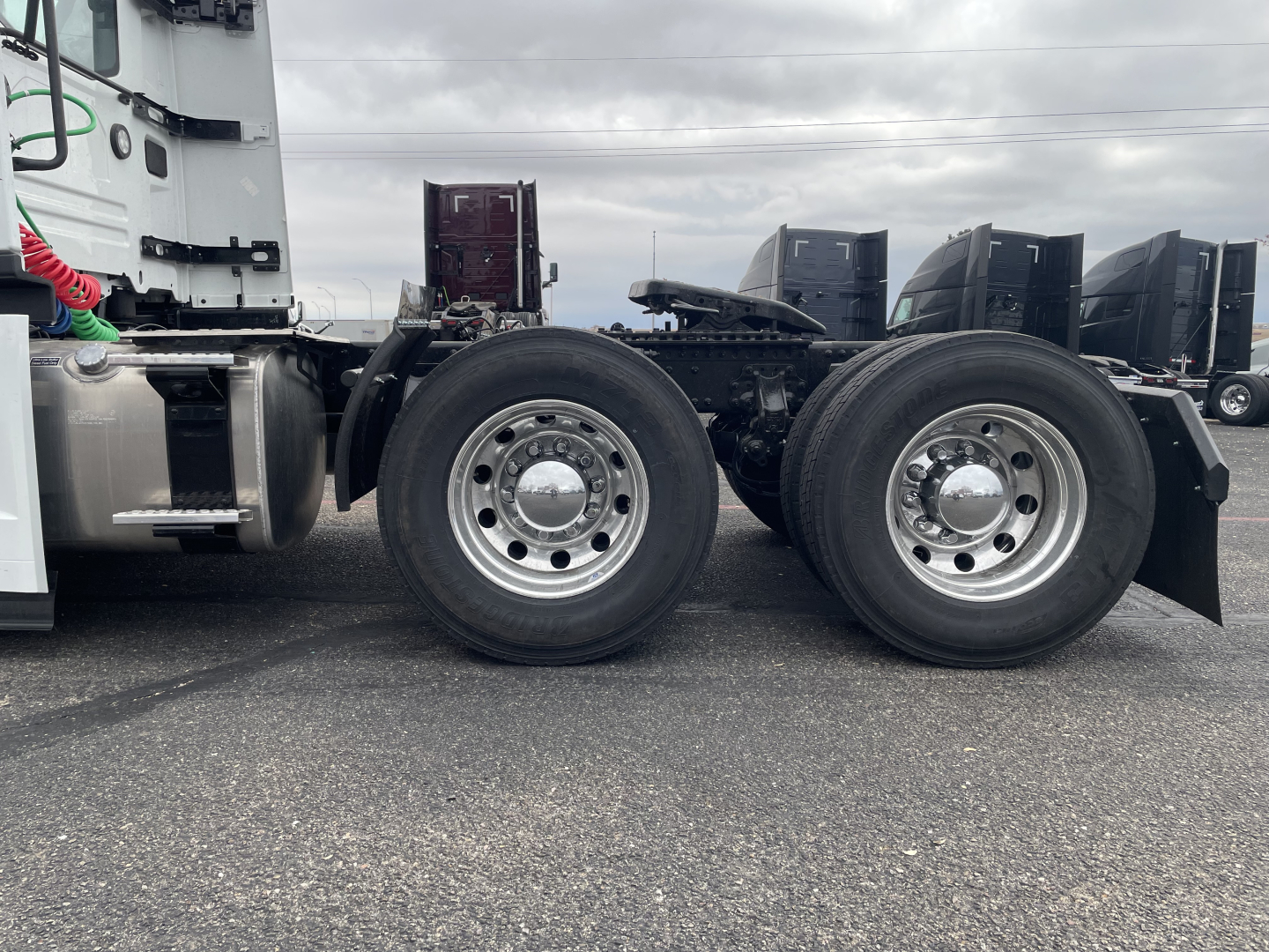 Mack PR64T truck chassis showing dual rear axles with polished wheel hubs and tires, side view of cab, fuel tanks, and undercarriage components.