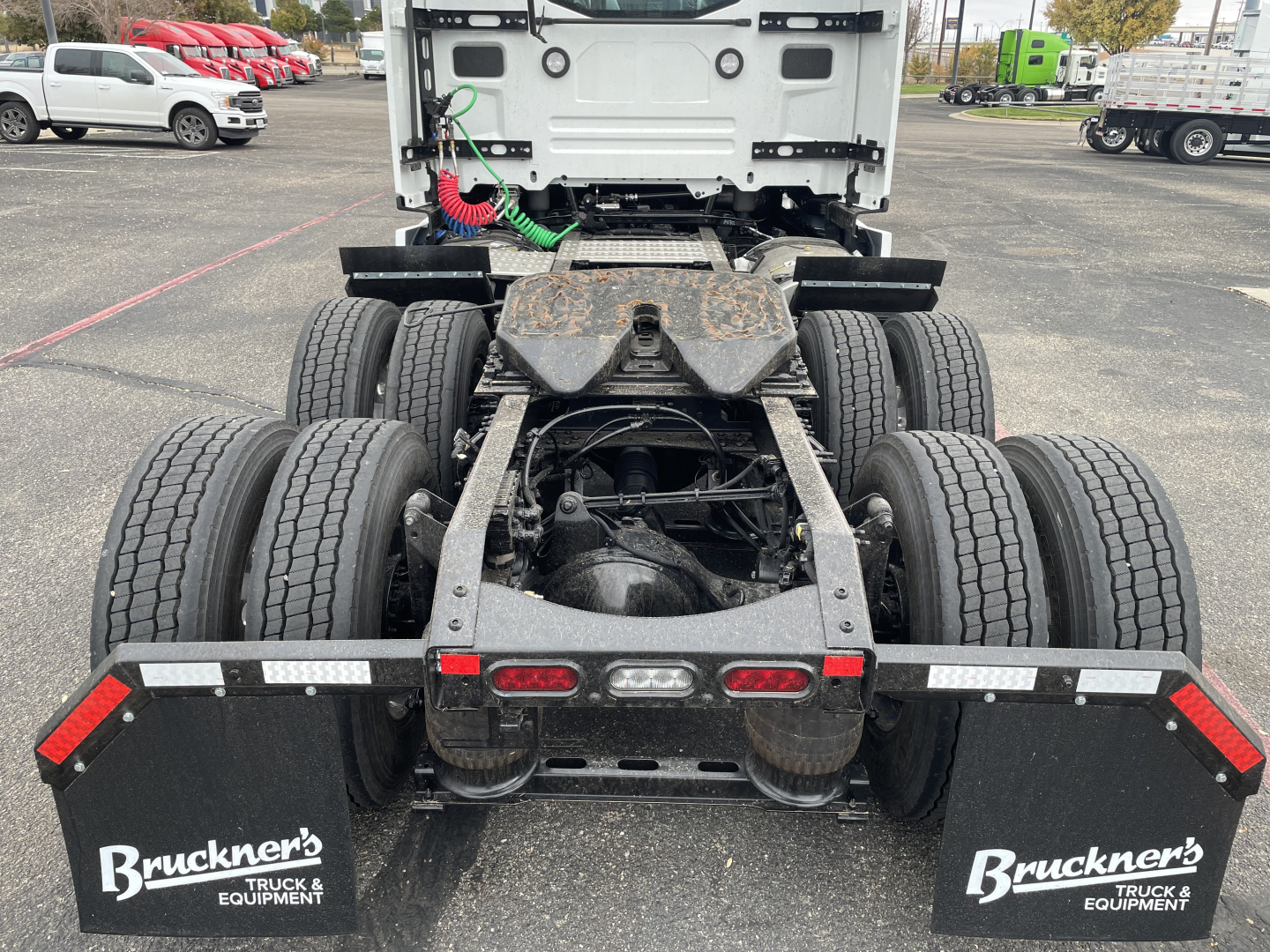 Rear view of a Mack PR64T truck chassis showing twin rear axles, fifth wheel area, mud flaps with Bruckner’s logo, and taillights. Visible labels include Bruckner’s on mud flaps and the exposed frame and drivetrain components.