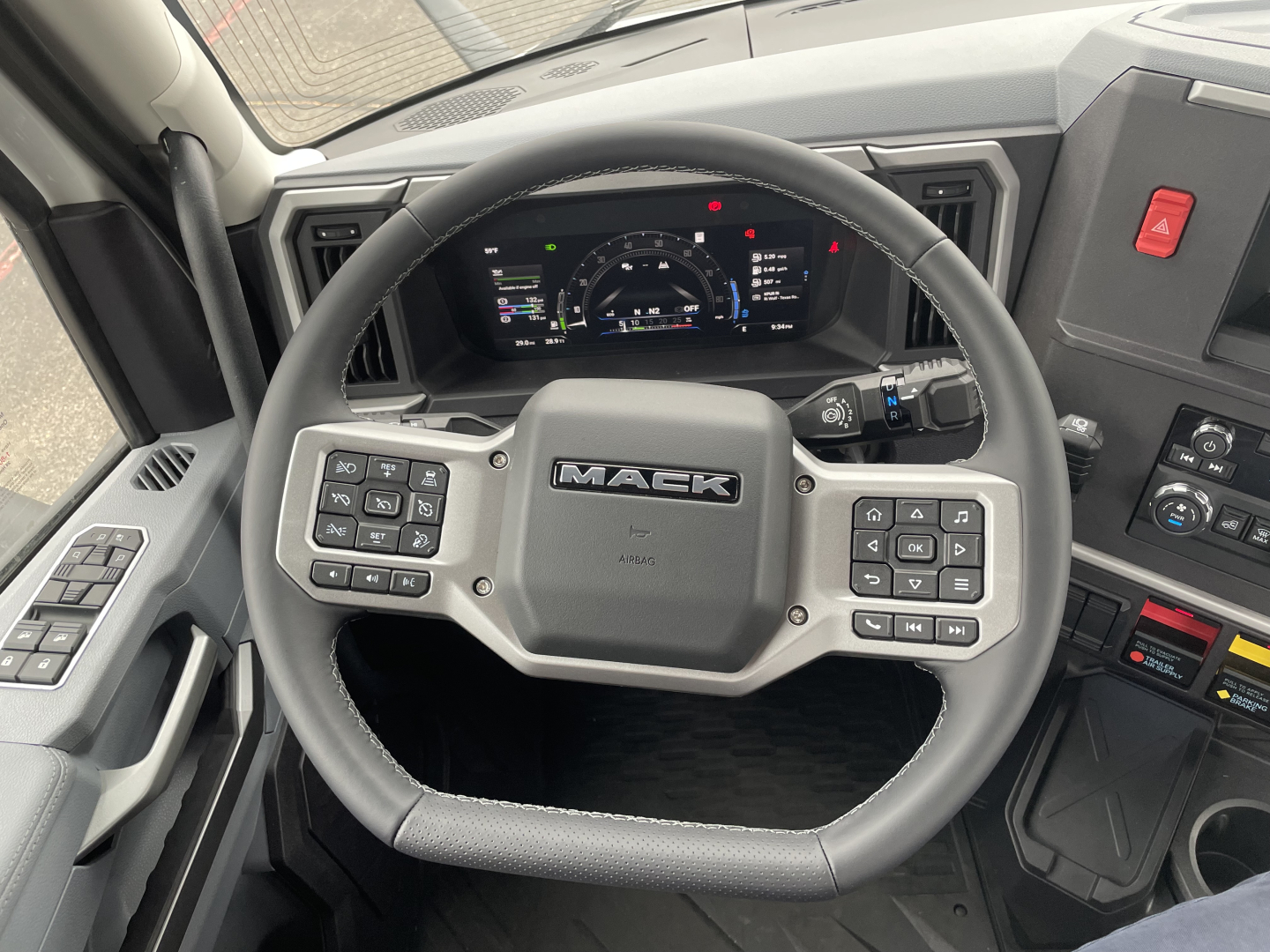 Steering wheel and dashboard of a new 2026 Mack PR64T tractor showing digital gauge cluster and steering wheel controls.