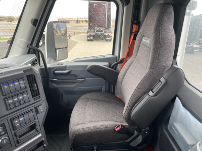 Seat and cab interior of a 2026 Mack PR64T tractor showing gray fabric driver seat and dashboard controls.