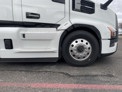 Front-right side of a white 2026 Mack PR64T conventional daycab showing front wheel and side step