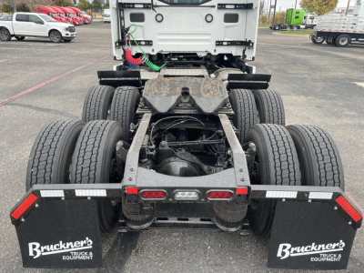 Rear view of a Mack PR64T truck chassis showing twin rear axles, fifth wheel area, mud flaps with Bruckner’s logo, and taillights. Visible labels include Bruckner’s on mud flaps and the exposed frame and drivetrain components.