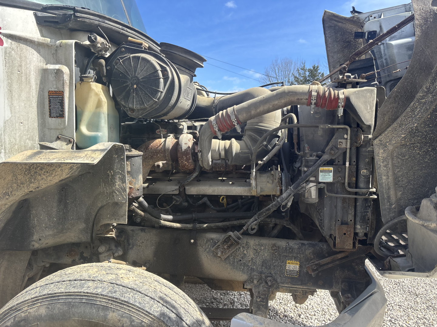 Truck engine bay of a 2000 Mack CH613 day cab showing engine components and hoses.