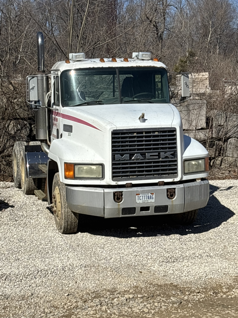 Front view of a white 2000 Mack CH613 day cab tractor. Large black grille with MACK badge, rectangular headlights, chrome bumper, stacked exhaust stacks, orange clearance lights on roof, side mirrors, and a New York license plate.