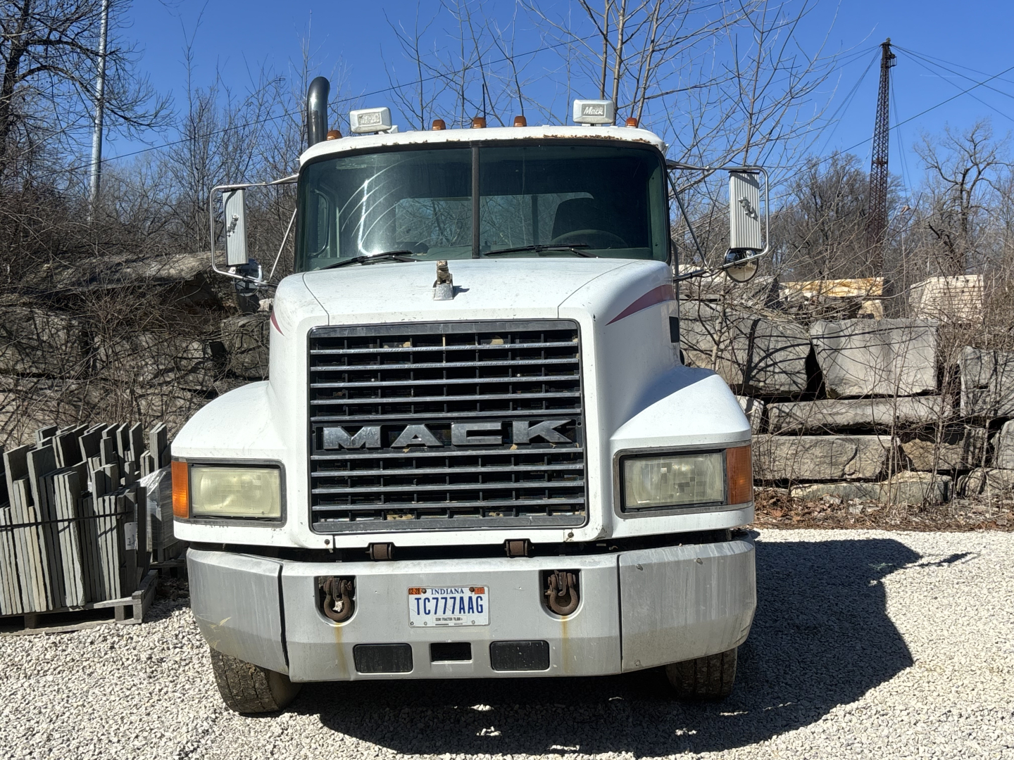 Truck front view of a Mack CH613 day cab showing large grille, rectangular headlights, and front bumper with license plate.