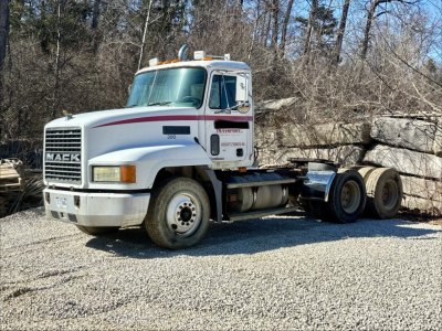 Mack CH613 day cab truck in-service showing front grille, white cab with red stripe, front wheel and sleeper window, chassis rear with dual axles and hitch.