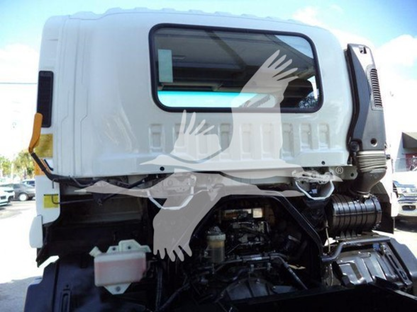 Truck cab and engine bay of a 2018 Isuzu FTR with visible engine components and wiring.