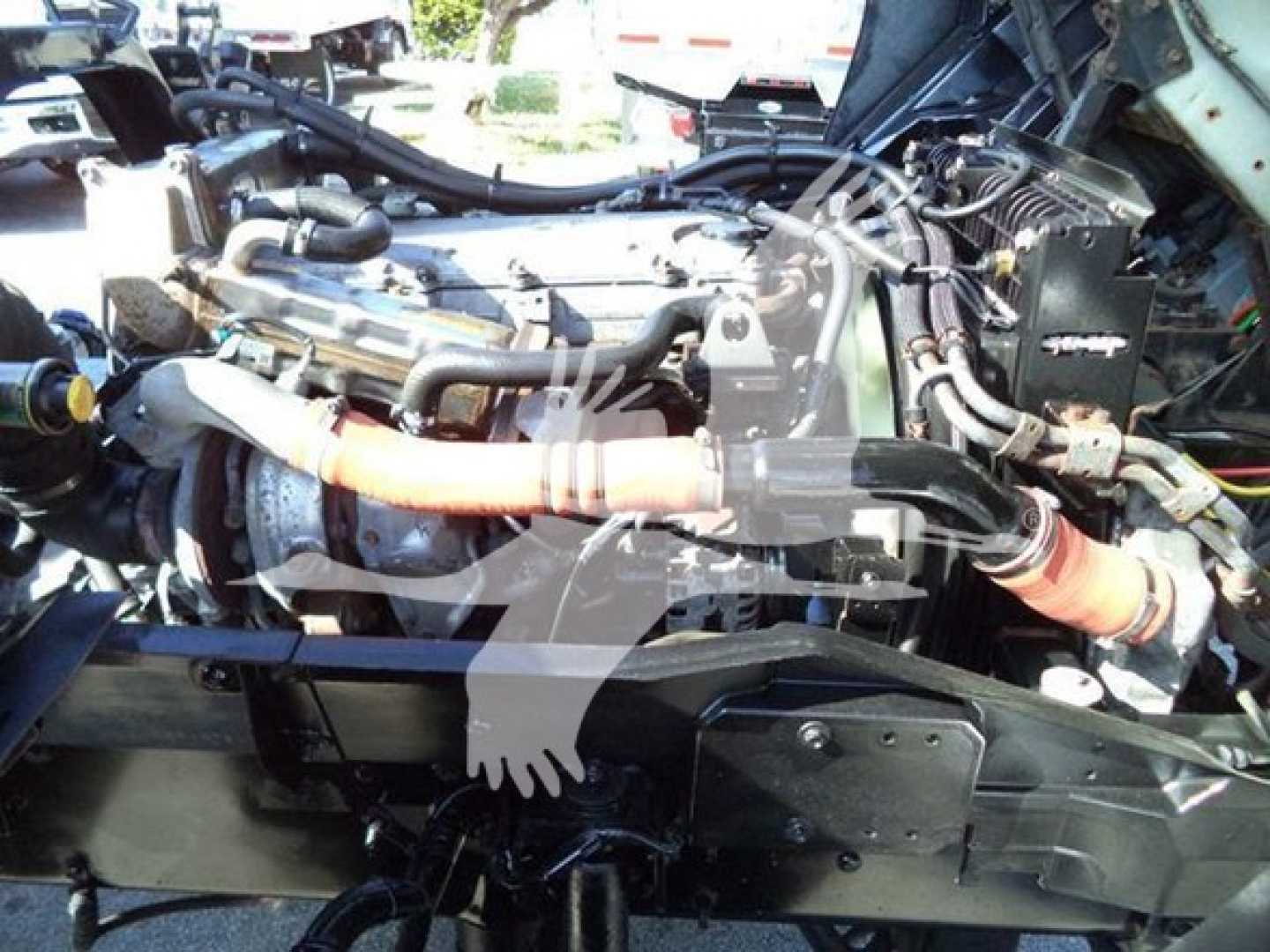 Isuzu FTR engine bay view showing components and hoses; no legible labels clearly visible in the image.