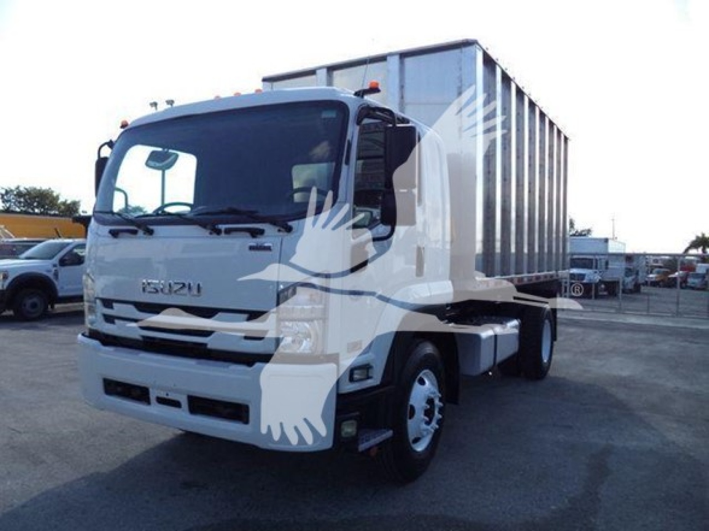 Isuzu FTR dump truck in service showing front and side view with white cab and large gray dump body.