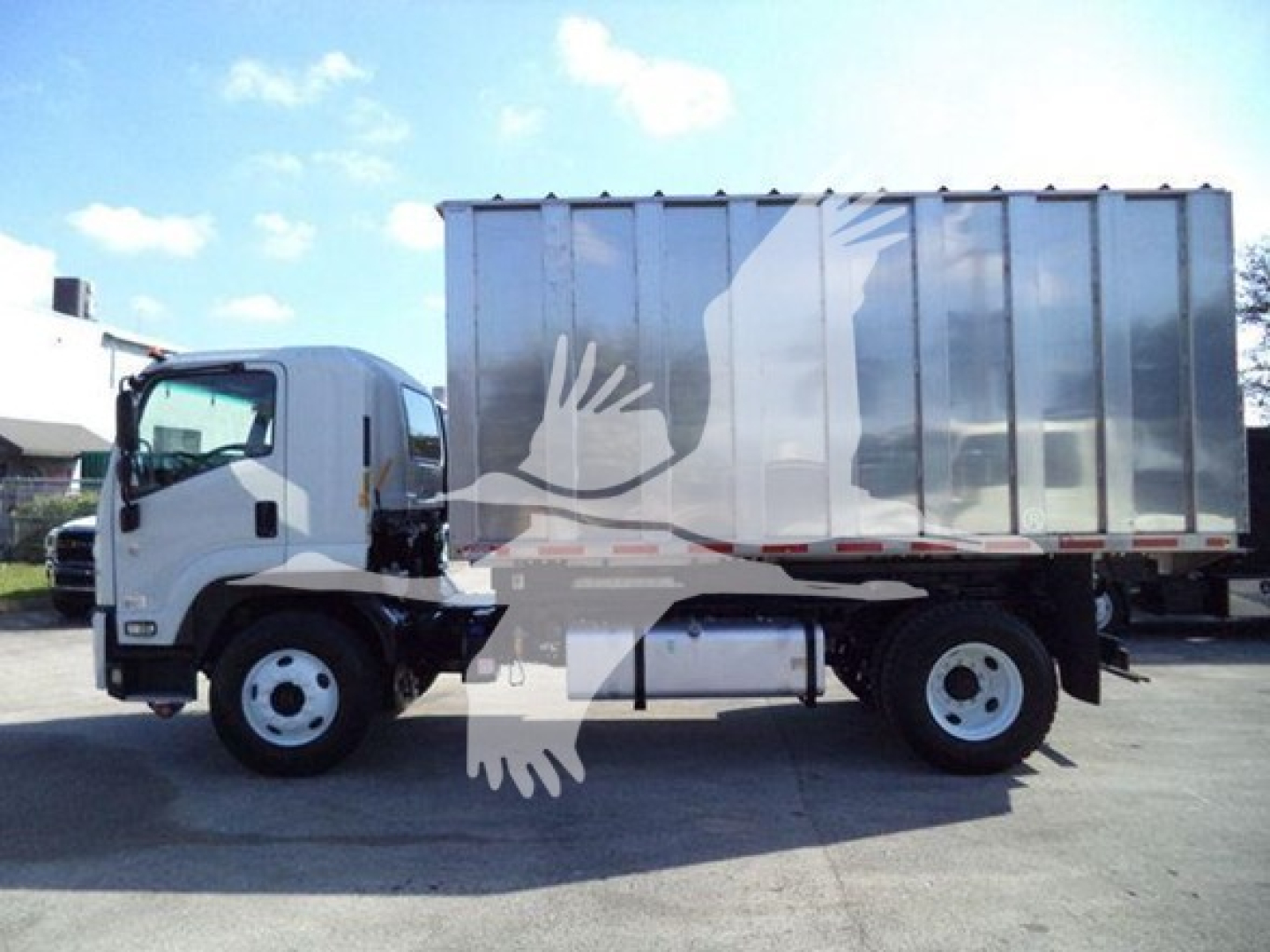 Isuzu FTR dump truck side view showing cab, large silver dump bed with vertical panels and white wheels.