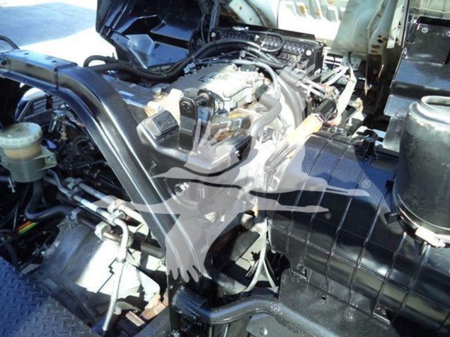 Engine bay of a 2018 Isuzu FTR showing hoses, wiring, and air intake with engine components visible