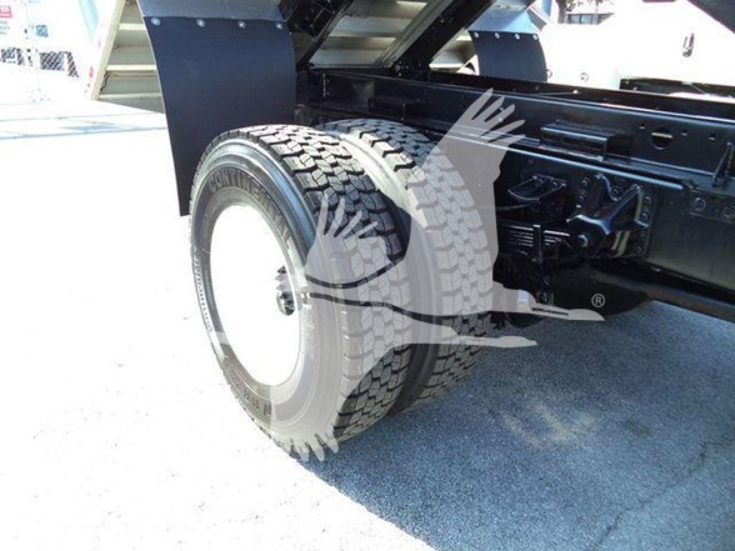 Isuzu FTR truck rear wheel area showing heavy-duty dual rear tires and chassis components.