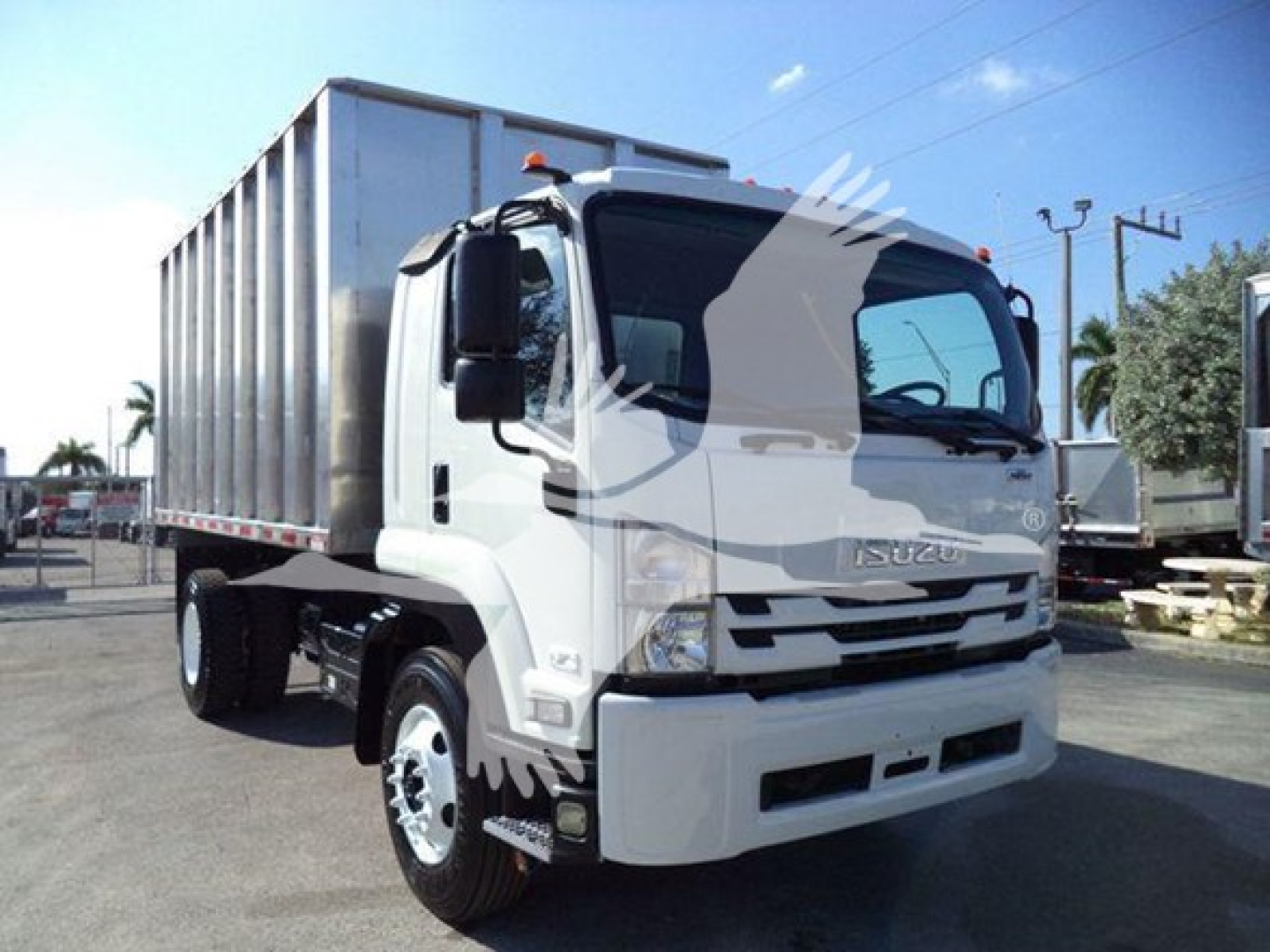 Isuzu FTR truck in a yard showing cab and chassis with a container bed.
