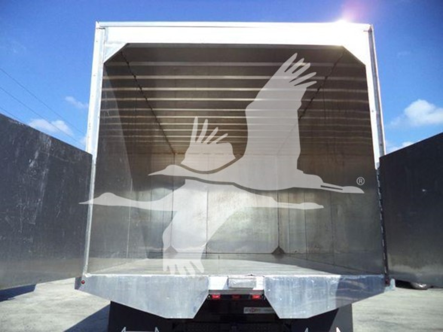 Isuzu FTR truck cargo area with open container showing empty bay and reflective metal interior.