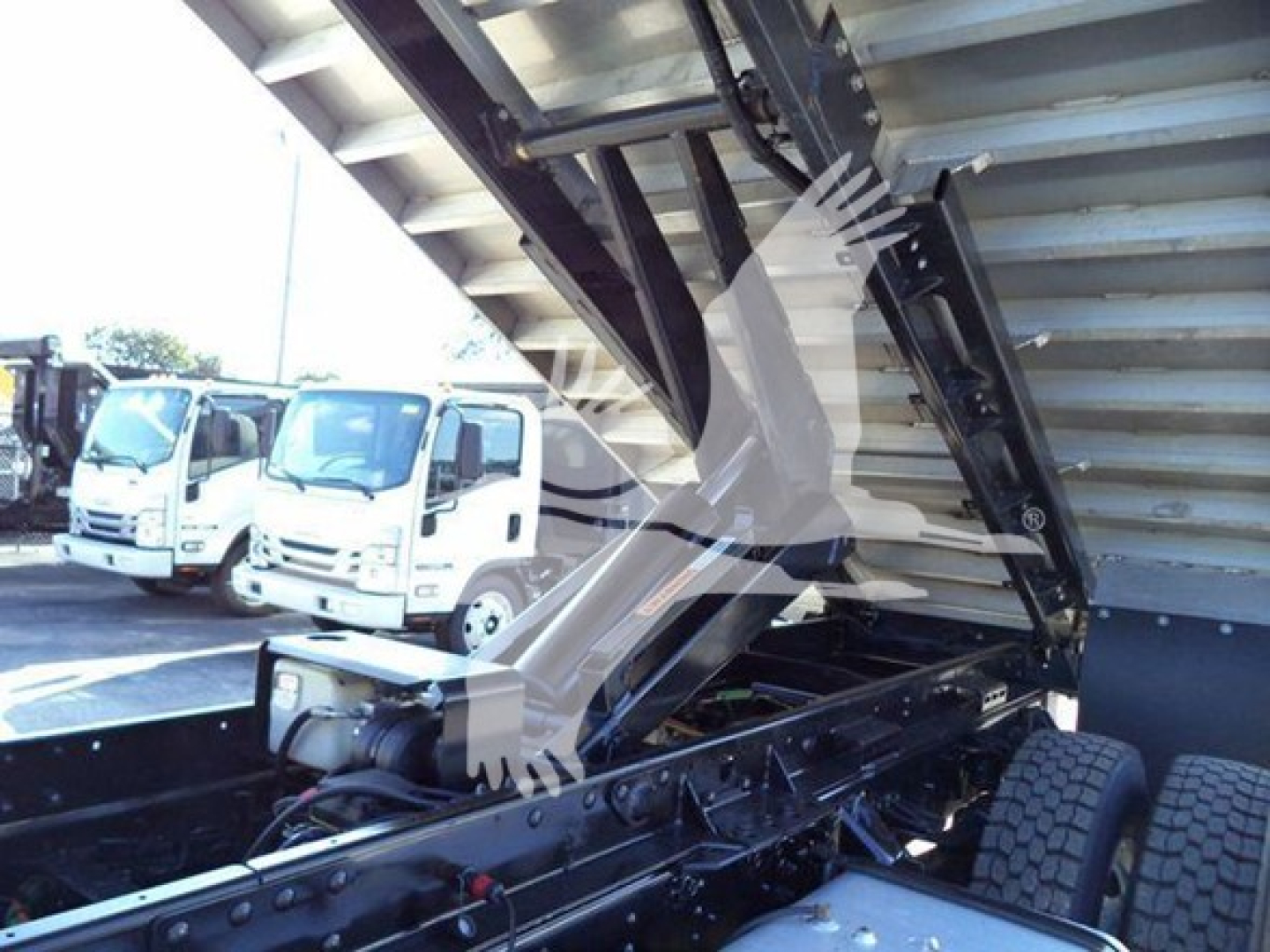 Isuzu FTR truck chassis with raised hydraulic bed and dual rear wheels visible