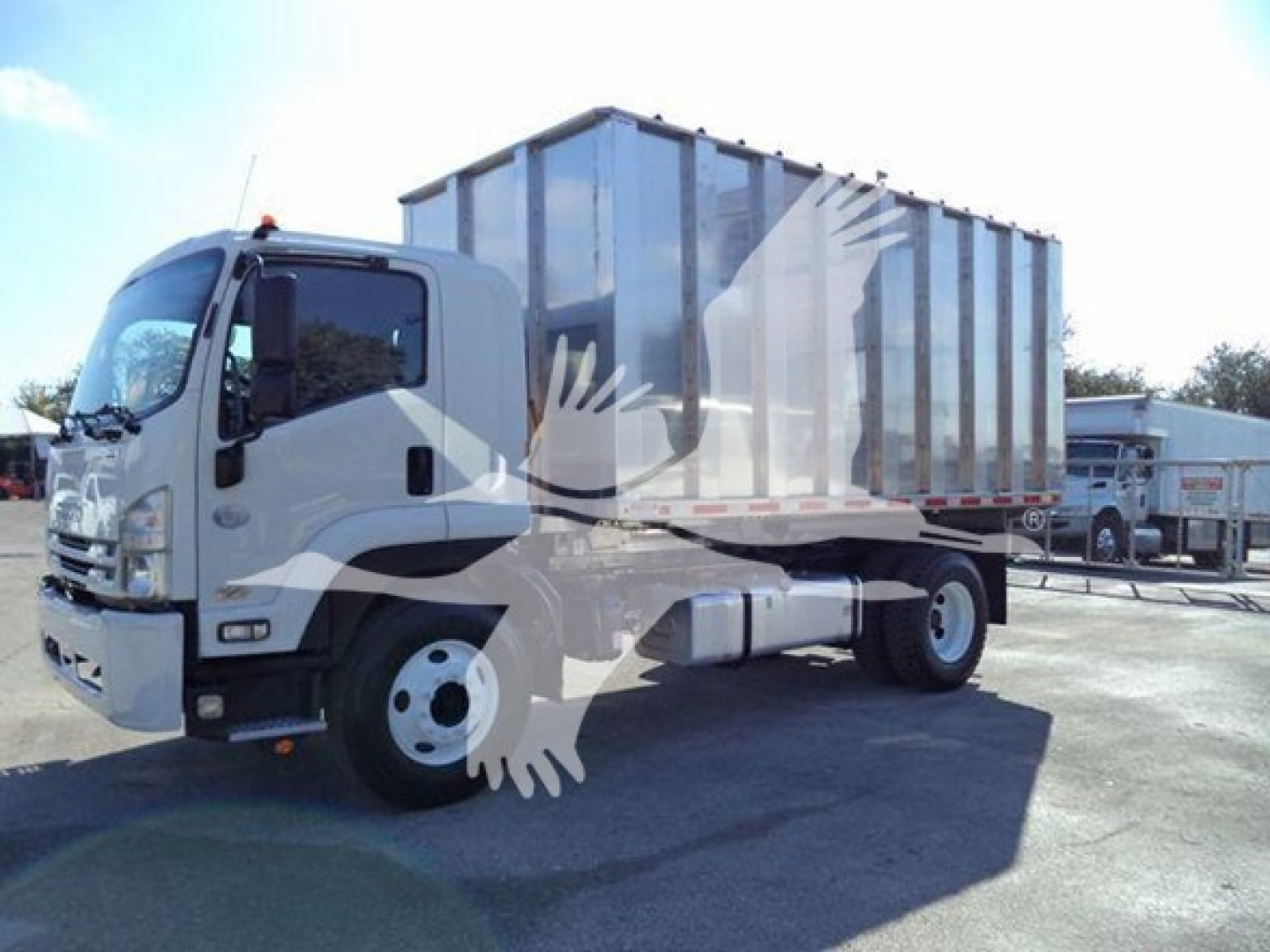 Isuzu FTR truck with large steel chipper body mounted, side view showing cab and chassis.