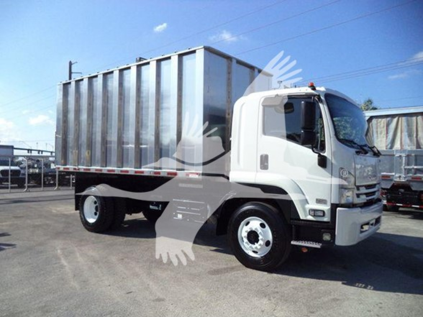 Isuzu FTR truck with a large metal dump bed chassis, side view, white cab and gray container, 2018 model year.
