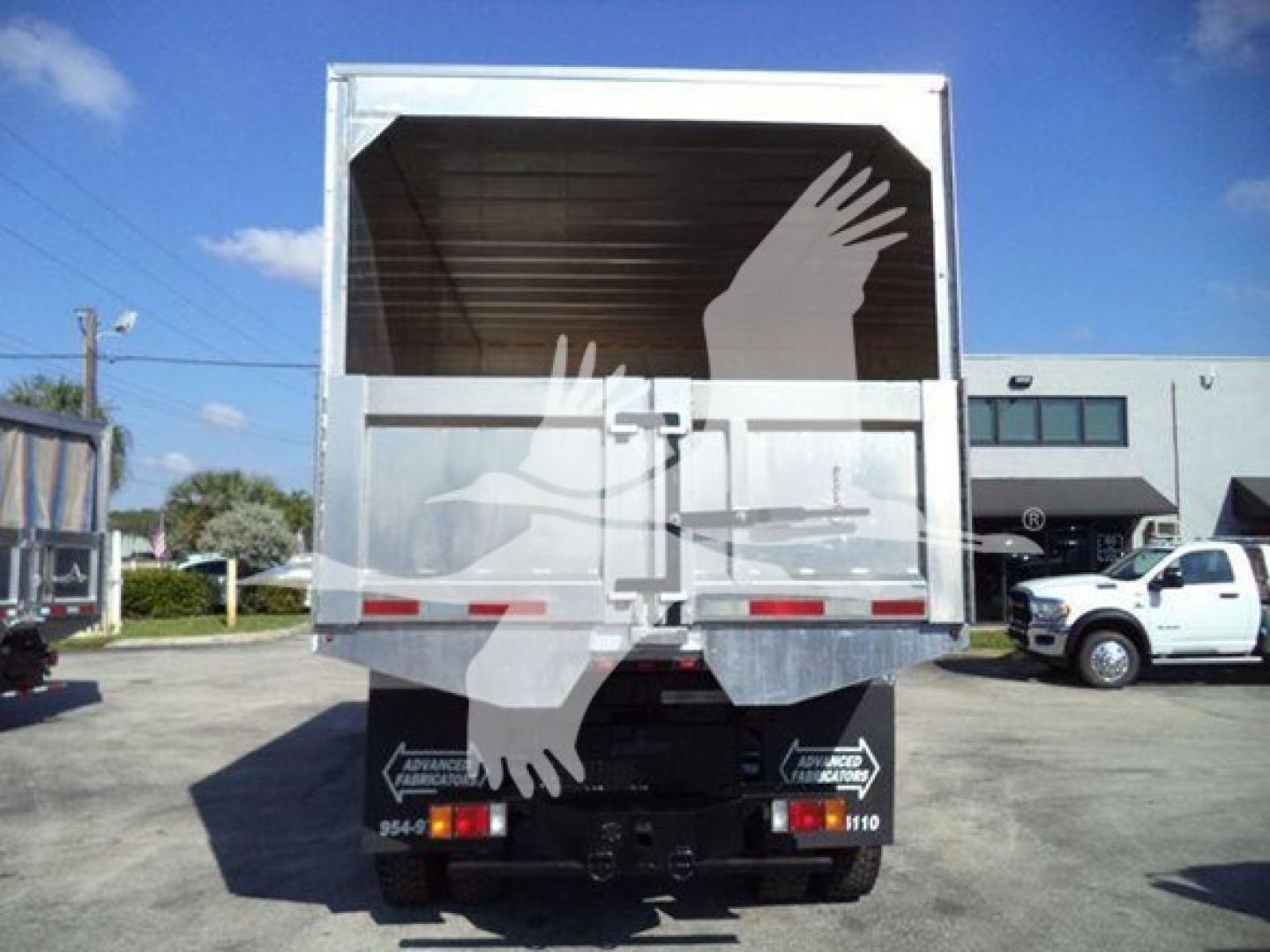Isuzu FTR truck rear view showing cargo bed and reflective tail lights.