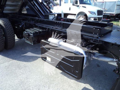Isuzu FTR chassis showing underbody tool box and frame rail with hydraulic equipment visible in background.