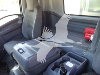 Isuzu FTR cab interior showing gray seats and center console with cup holder and control switches.