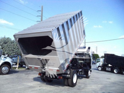 Isuzu FTR truck with a raised dump bed showing the underside and tailgate area.
