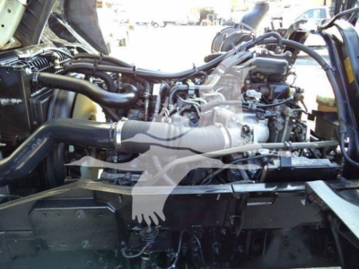 Isuzu FTR engine bay showing manifold, hoses, and engine components in view.
