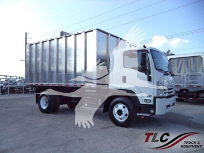Isuzu FTR truck with a large dump bed, side view showing cab and cargo area, white cab with chrome grille, in-service equipment.