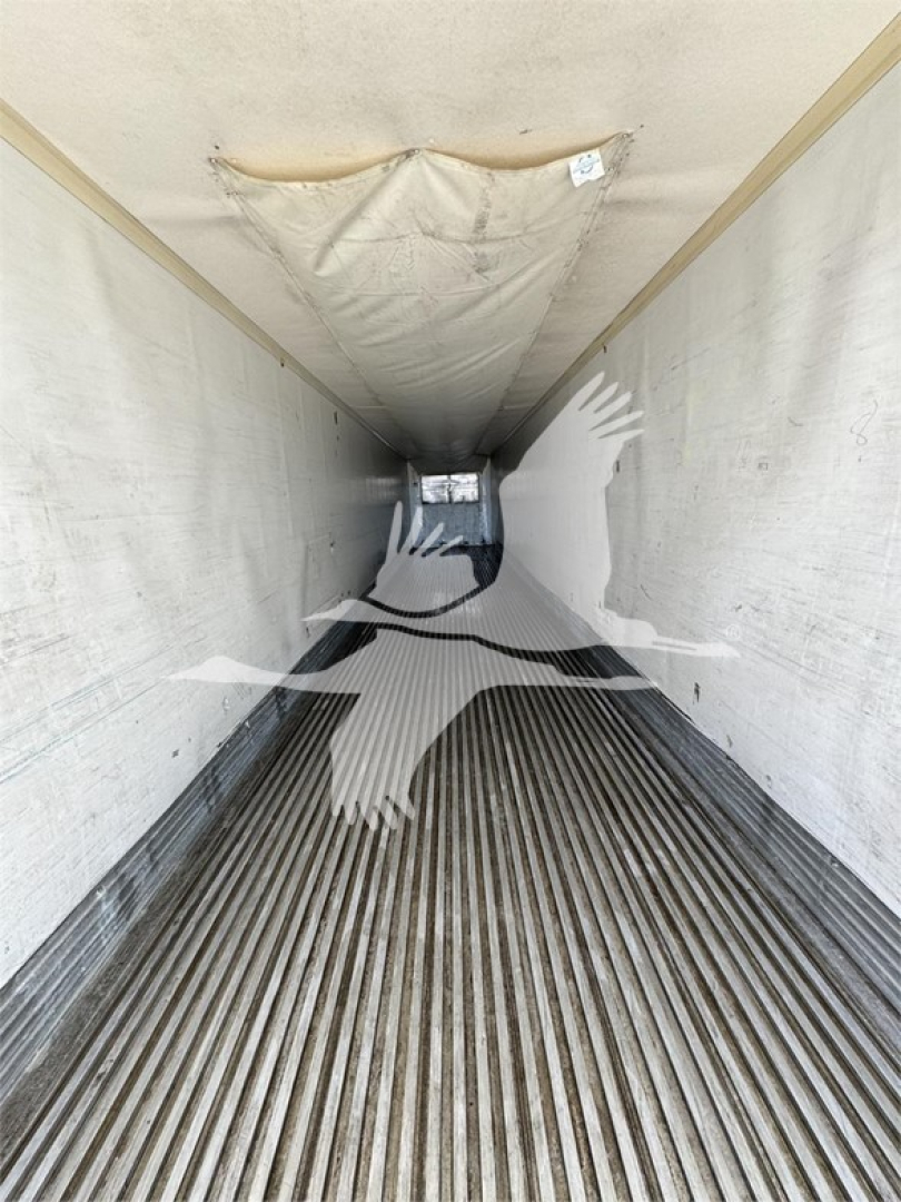 Trailer interior showing ribbed floor and walls of a reefer with natural light at far end