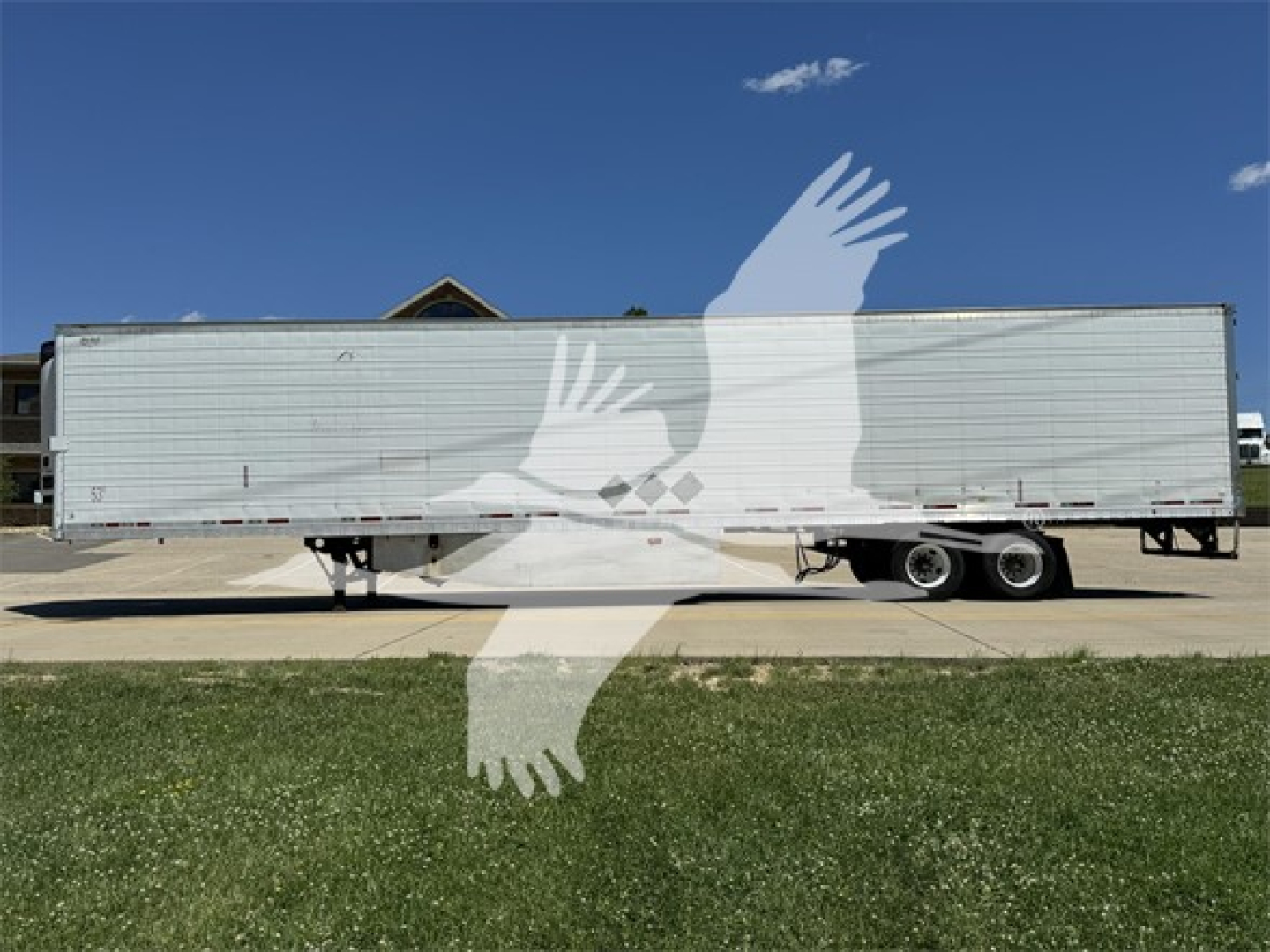 Reefer trailer side view showing silver exterior and tandem wheels under a clear sky.