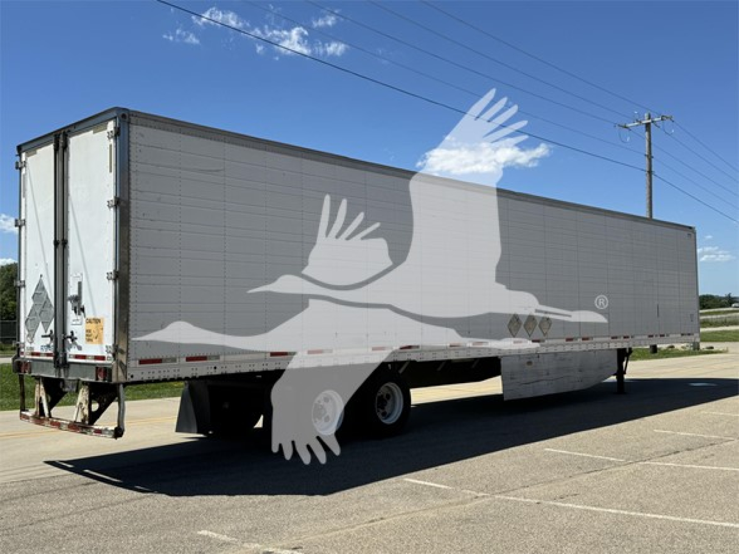 Trailer side view of a 2011 Wabash reefer trailer showing a two-axle configuration with a gray exterior and reflective markings.