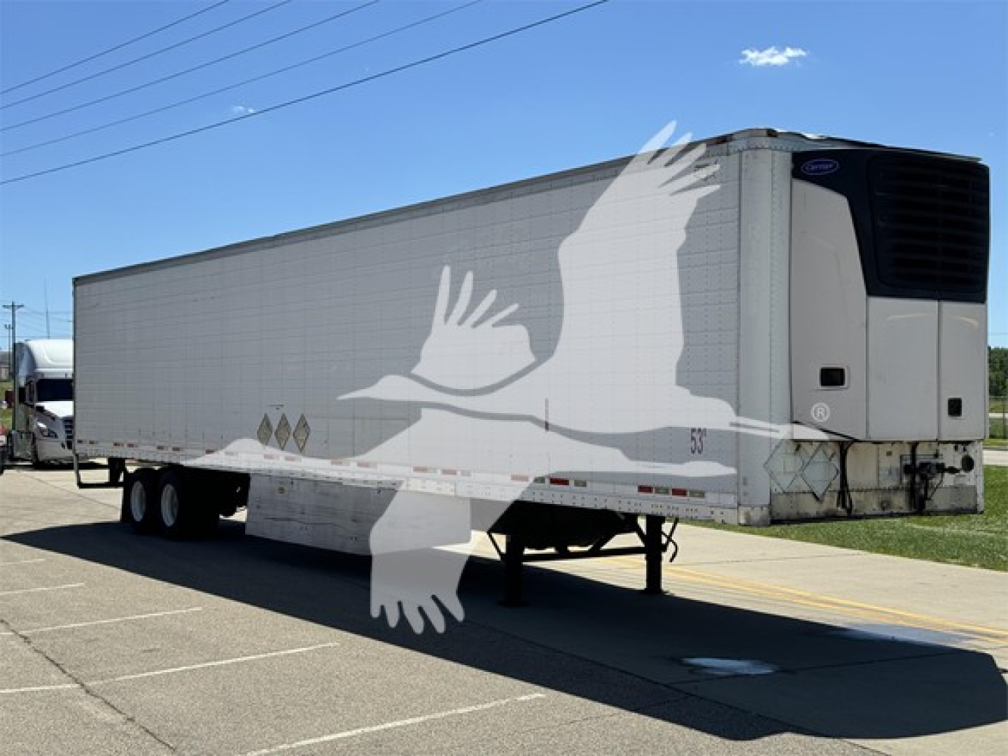 Wabash reefer trailer showing side decals and refrigeration unit at front-right, three-axle with tandem wheels, raised landing gear.