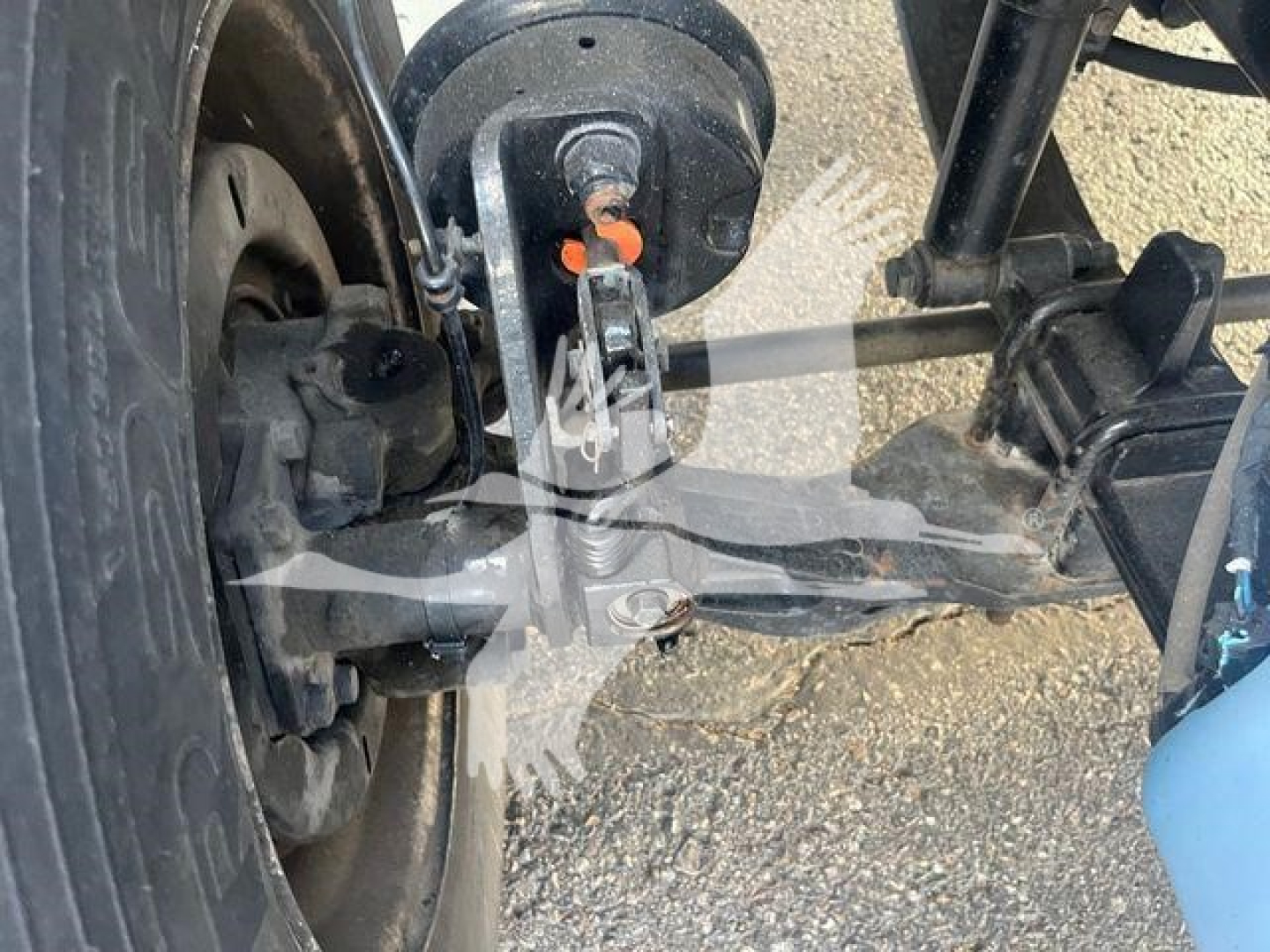 Freightliner M2 106 front suspension and steering linkage with wheel, axle, and frame components visible.